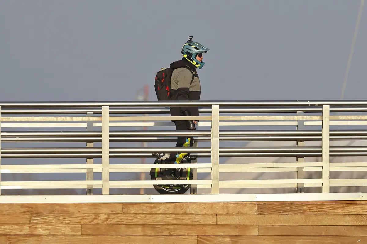 man riding euc on a bridge