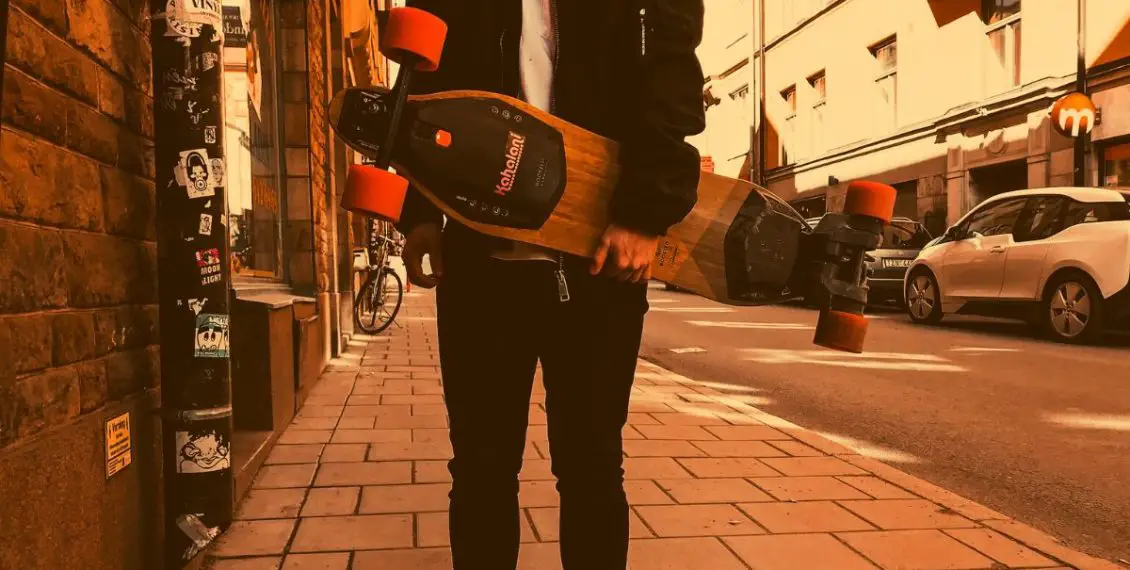 person holding electric mountain board